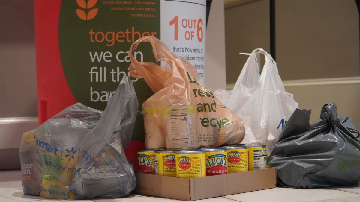 Bags of Canned Goods Sitting in front of Food Donation Bin